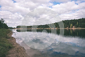 calm lake with reflections of clouds in summer- vintage retro l