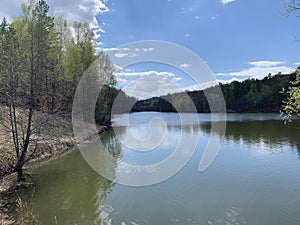 Calm lake surface in beautiful forest surroundings.