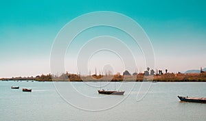 Calm lake with two fishing boats. Fresh water lagoon in Estany de cullera. Valencia, Spain