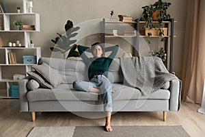 Calm Latino woman relax on sofa breathe fresh air