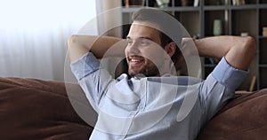 Calm man put hands behind head lean on comfy sofa