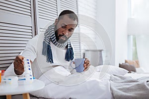 Calm man taking his pills while being ill