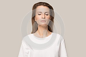Calm mindful woman with closed eyes breathing deep, no stress