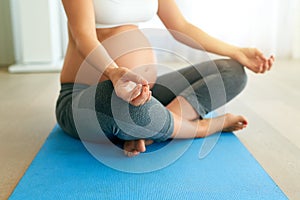 Calm mommy, calm baby. a pregnant woman meditating on an exercise mat at home.