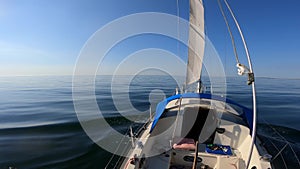 Calm nature background of open sea water with light waves in slow motion during sunrise