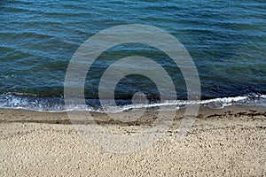 Calm ocean waves on an empty beach on a sunny day, vacation background with copy space, Baltic Sea