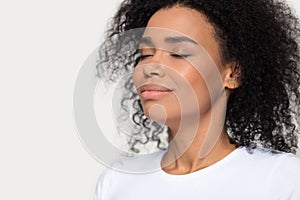 Calm peaceful African American woman breathing deep close up