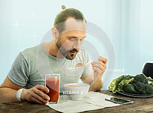 Calm pleasant man sitting and eating.