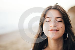 Calm portrait of happy fashionable boho woman relaxing at sandy cliff on tropical island. Stylish hipster girl walking on beach at