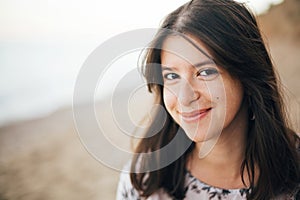 Calm portrait of happy fashionable boho woman relaxing at sandy cliff on tropical island. Stylish hipster girl walking on beach at