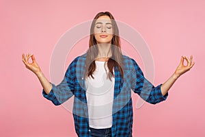 Calm positive girl in checkered shirt holding hands in mudra gesture and meditating, practicing pranayama yoga