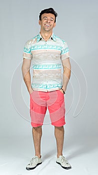 Calm and relaxed man with hands in his pocket. Handsome brazilian male wears colorful summer shirt. 30s..