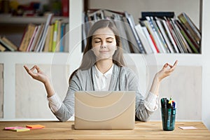 Calm relaxed woman meditating with laptop, no stress at work photo