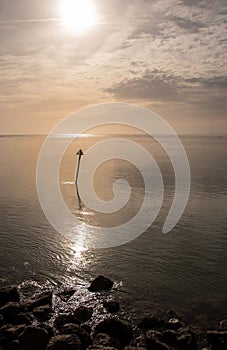 Calm and relaxing seascape with reflective still waters in low amber light,