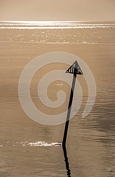 Calm and relaxing seascape with reflective still waters in low amber light,