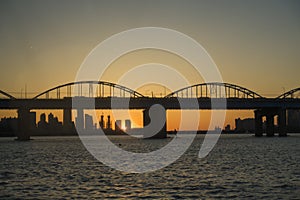 A calm river and an arch bridge and sunset at Hangang Park, Seoul, South Korea