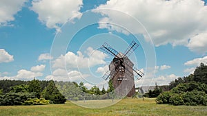 Calm Rural Landscape with a Farm House and Traditional Wooden Windmill in Summer