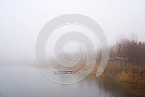 Calm scene at a lonely lake in fog
