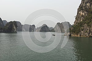 A calm sea with a boat in the middle of it in Ha Long Bay Hanoi Vietnam photo