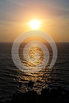 Calm sea in mysterious light of setting sun, a haze over the horizon. Sunset over the sea, sunlight reflected from the surface of