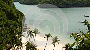 Calm sea near green jungle. Peaceful ocean with turquoise water, white sandy tropical shore in Ang Thong paradise national park,