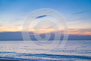 Calm sea with sunset sky and sun through the clouds over. ocean and sky background. Tranquil seascape. Horizon over the water.