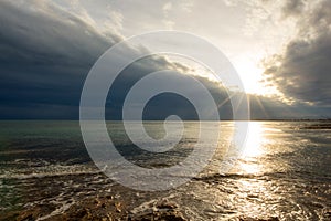 The calm sea in a very cloudy sunset