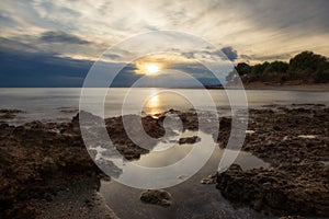 The calm sea in a very cloudy sunset