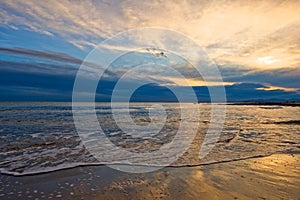 The calm sea in a very cloudy sunset