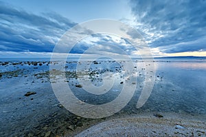 Calm sea water with water reflection. Blue hour