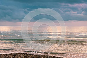 Calm sea waves against a dark and stormy sky