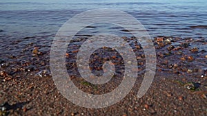 Calm sea and waves during the day on the beach close-up.