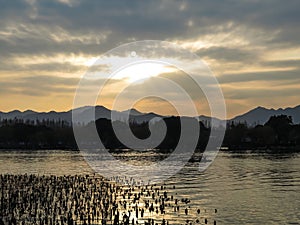 A calm seascape with mountains at sunset. Dramatic sky and cloudscape