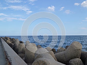 Calm seascape in a summer sunny day from old breakwater with tetrapods