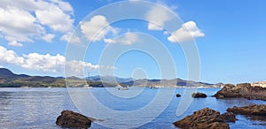 Calm seascape with yachts and mountain views.