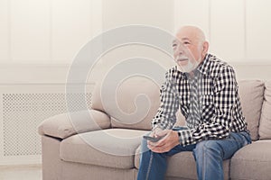 Calm senior man watching tv copy space