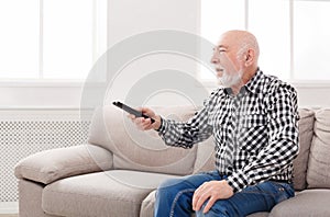 Calm senior man watching tv copy space