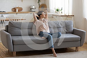 Calm serene young woman relaxing on couch at home