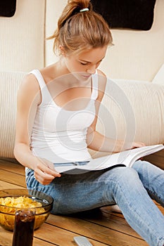 Calm and serious teenage girl with magazine