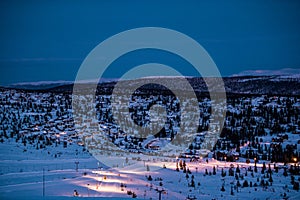 Calm Skiing resort during the night. Winter holiday in the mountains, foggy mountain forest, snow and skiing.