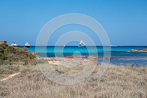 calm torquoise Balearic sea in the sunny day with moored boats  Formentera beach photo