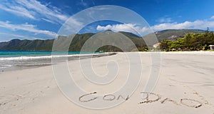 Calm Tropical Beach With Inscription Con Dao Written On A Sand