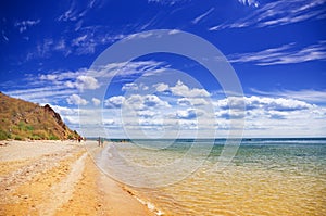 Calm warm sea washing the beach and blue summer sky