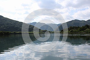 A panoramic view of mountains and dense forests from the river in Amami Oshima Island photo