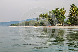 Calm water, palm trees and white sand beach at Tokeh Beach, south of Freetown, Sierra Leone, Africa
