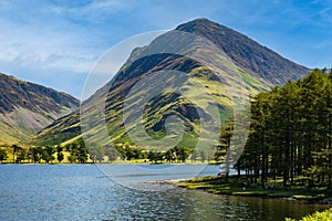 Calm waters of Buttermere with the tall mountain of Fleetwith Pike and the Honnister Pass behind (Lake District