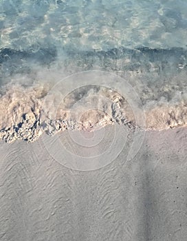 A calm wave on a pink sand beach photo