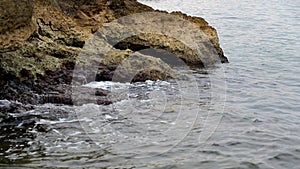 Calm waves hiting rocks on a gloomy day