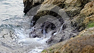 Calm waves hiting rocks on a gloomy day