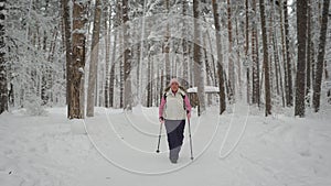 Calm woman goes in for sports in the winter cold forest. She warmly dressed in sportswear. is energetically along th